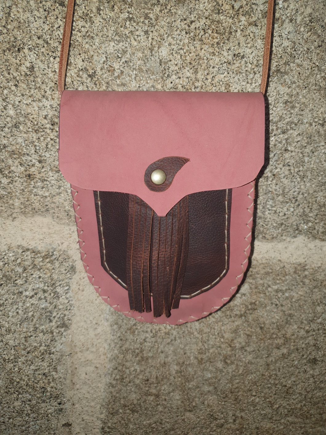Petit sac artisanal arrondie en cuir rose et marron, à franges.